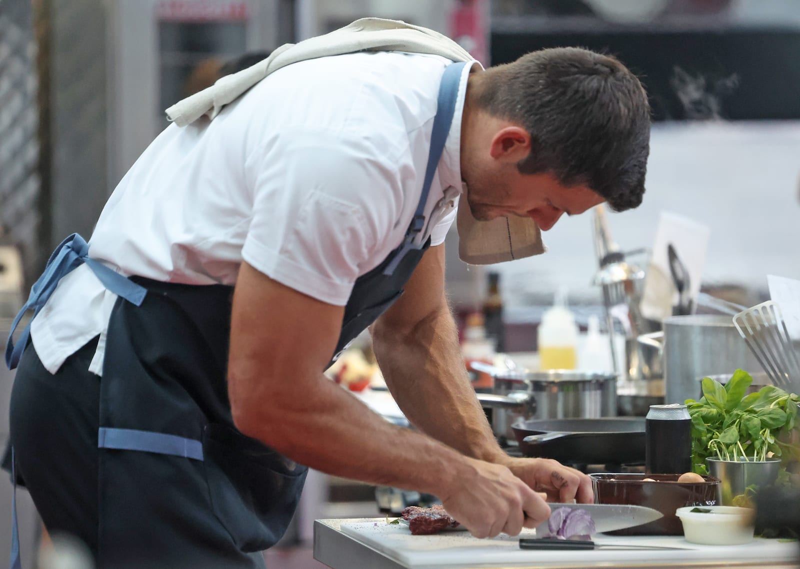 Jared Veldheer preparing a meal in the kitchen, chopping a red onion.